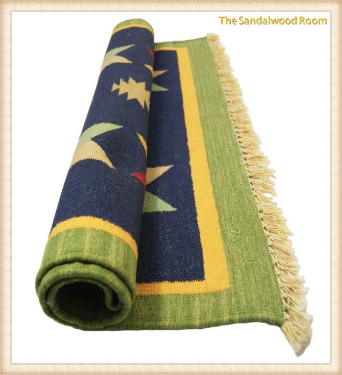 Hand knotted rug in colours of spring rolled up, the sandalwood room