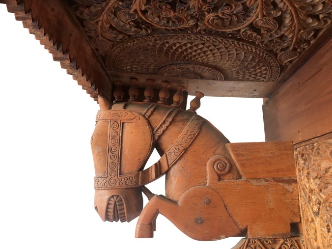 horse bust of galloping horse supporting carved header of carved doorway
