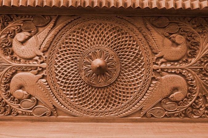 intricately carved header of an 80 year old vintage doorway, the sandalwood room